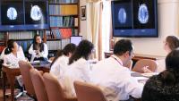 neurology residents looking at the slides and discussing cases at a library